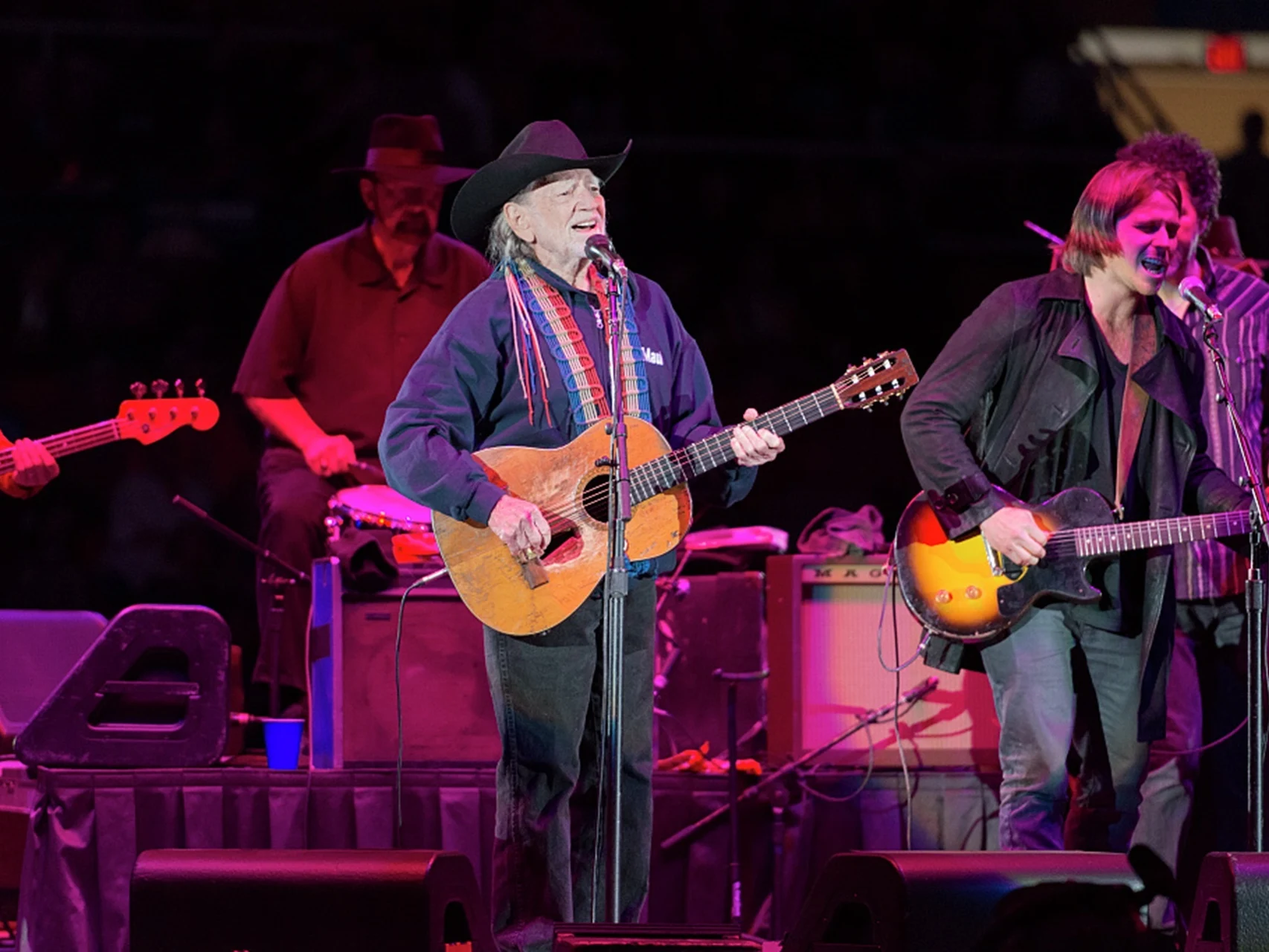 Foto ao vivo de Willie Nelson se apresentando com violão