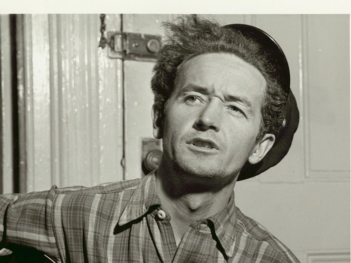 Photo of Woody Guthrie with guitar
